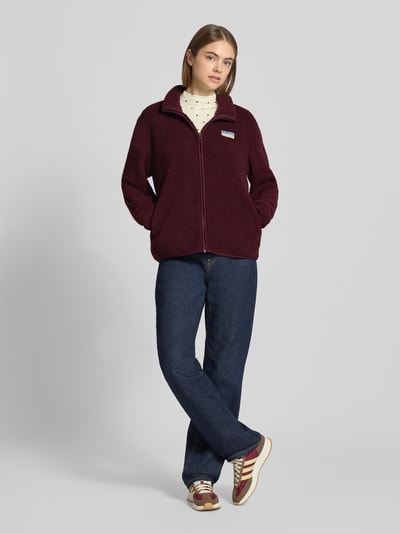 Vrouwenmodel draagt Regular fit fleecejack met ritssluiting model 'EVA' van ONLY in bordeaux, structuur zachte stof, donkere jeans, geheel vooraanzicht, Dames fleecejack van ONLY