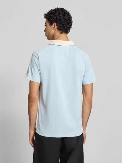 Männermodel trägt Regular Fit T-Shirt mit Umlegekragen Modell 'Heritage' von KARL KANI in Hellblau mit Logo-Stitching, Rückenlänge 70 cm, Ganzkörperansicht Rückansicht.