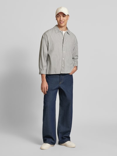 Männermodel trägt Wide Fit Jeans im 5-Pockets-Design Modell 'Dave' von Jack & Jones in Dunkelblau, reine Baumwolle, Ganzkörperansicht von vorne