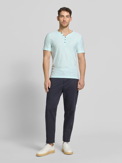 Männermodel trägt T-Shirt mit V-Ausschnitt und Knopfleiste von MCNEAL in Hellblau aus Reine Baumwolle, Regular-Fit, Ganzkörperansicht von vorne. Rückenlänge bei Größe M: 68 cm.
