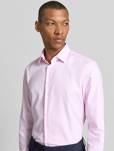 Männermodel trägt Slim Fit Business-Hemd mit Kentkragen von Jake*s aus Reine Baumwolle, zart rosa, feine Struktur, Nahaufnahme Oberkörper.