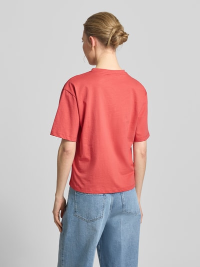 Frauenmodel trägt T-Shirt mit Lochstickerei und Rundhalsausschnitt von Jake*s Casual aus reiner Baumwolle in Rot, Regular Fit, glatte Textur, kombiniert zu blauer Jeans, Ganzkörperansicht Rückansicht.