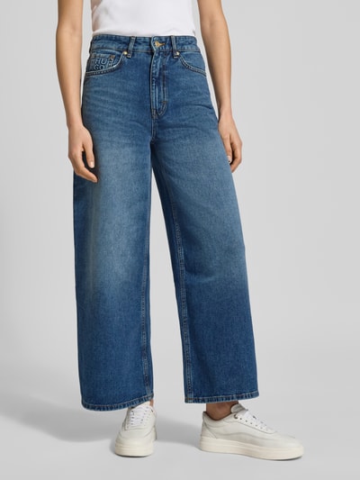 Frauenmodel trägt Regular Fit Wide Leg Jeans aus reiner Baumwolle Modell 'Geredith' von HUGO, unifarbener blauer Denim, 5-Pocket-Design, Ganzkörperansicht von vorne.