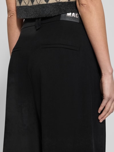 Frauenmodel trägt Hose aus Viskose-Mix mit weitem Bein von MAC, schwarze Farbe, Gesäßtaschen, Detailaufnahme Rückansicht.