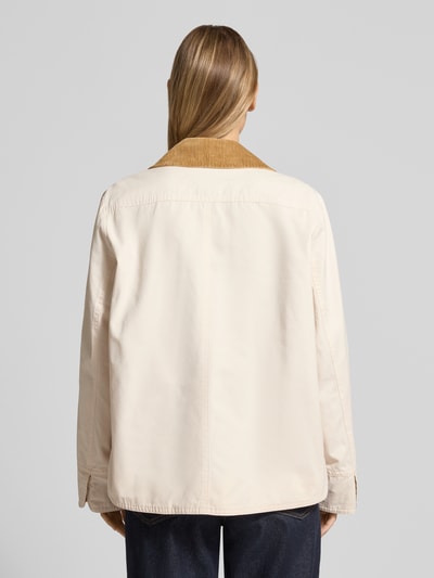 Vrouwenmodel draagt Jacke mit Umlegekragen und aufgesetzten Pattentaschen van WHITE LABEL in recht model met platte kraag, drukknoopsluiting, opgestikte klepzakken, ruglengte maat 36: 67 cm, schouderbreedte 44 cm, borstwijdte 53 cm, mouwlengte 63 cm, lichte kleur, gladde textuur, donkere kraag, Ganzkörperansicht Rückansicht.