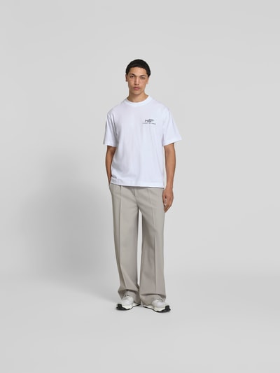 Männermodel trägt Regular Fit T-Shirt mit Statement-Print von Closed aus Reiner Baumwolle, weiß, lockere Form, Ganzkörperansicht von vorne.