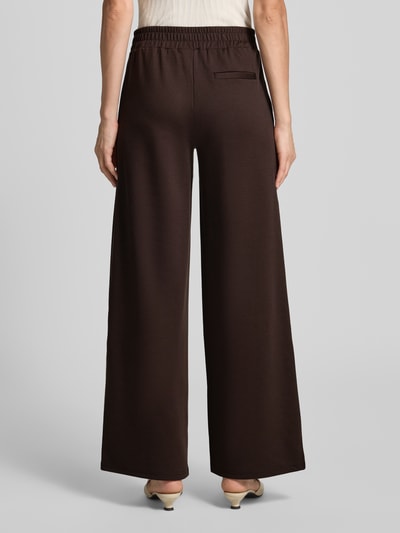 Frauenmodel trägt Hose mit weitem Bein Modell 'KATE' von ICHI, unifarben, elastischer Bund, Material-Mix, Gesäßtasche, Ganzkörperansicht Rückansicht.