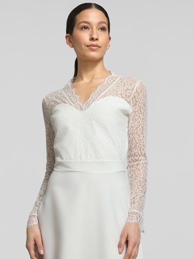 Frauenmodel trägt tailliertes Brautkleid mit V-Ausschnitt Modell 'Joanna' von GUIDO MARIA KRETSCHMER WOMAN, Spitze, Elastischer-Material-Mix, Nahaufnahme Oberkörper.