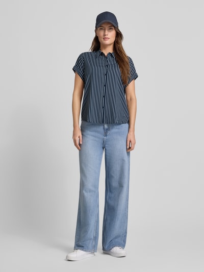 Frauenmodel trägt Regular Fit Hemdbluse aus Viskose-Mix Modell 'Majan' von Samsøe Samsøe, dunkelblau-weiß gestreift, kurzärmelig, ganzkörperansicht von vorne.