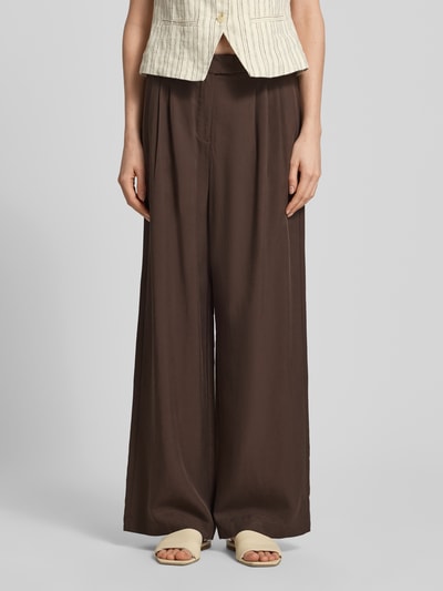 Frauenmodel trägt Wide Fit Leinenhose mit elastischem Bund von comma, braun, reine Leinenstruktur, Drapierungen, Ganzkörperansicht von vorne.