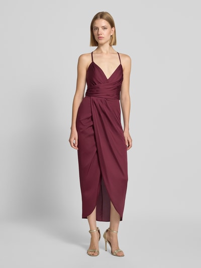 Frauenmodel trägt Midikleid mit gelegten Falten von Vera Mont, bordeauxfarbener Satin, tailliert, Spaghettiträger, V-Ausschnitt, Ganzkörperansicht von vorne.