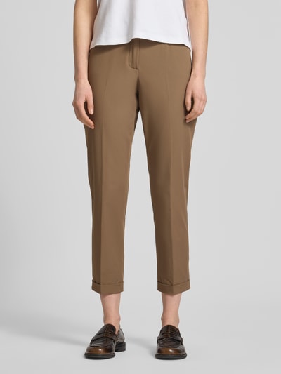 Frauenmodel trägt Chino aus Techno Cotton Superstretch Modell 'UTE' von Raffaello Rossi in Hellbraun, Elastischer-Material-Mix, Straight, Verkürzt, Knopf-Reißverschluss, Eingriffstaschen, Gesäßtaschen, Bügelfalten, Beinumschläge, Gürtelschlaufen, Bundweite 40 cm, Innenbeinlänge 68 cm, Ganzkörperansicht von vorne.