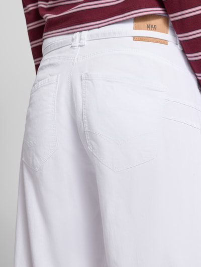 Männermodel trägt Wide Fit Jeans mit Zierschleife von MAC aus elastycznego bawełnianego materiału, 5 kieszeni, zamek i guzik, szerokość w rozmiarze 36/32: 38 cm, długość nogawki wewnętrznej: 82 cm, kolor biały, tekstura gładka, detailaufnahme Rückansicht.