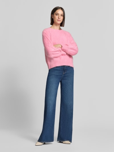 Frauenmodel trägt Regular Fit Pullover aus Kaschmir-Mix mit Woll-Anteil von HERZENS in Rosa, Strick-Optik, Jeans, Ganzkörperansicht von vorne.