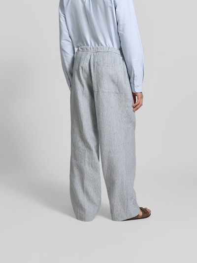 Mężczyzna nosi Wide Fit Stoffhose aus Leinen-Mix von Officine Générale, szare paski, elastyczny pas, kieszeń z tyłu, widok całej sylwetki z tyłu, długość nogawki 79 cm, szerokość w rozmiarze 50: 45 cm, tkanina z lnem i bawełną, kanty.