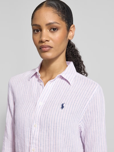 Frauenmodel trägt Hemdbluse aus reinem Leinen von Polo Ralph Lauren mit Streifenmuster, Knopfleiste, Label-Stitching, Nahaufnahme Oberkörper.