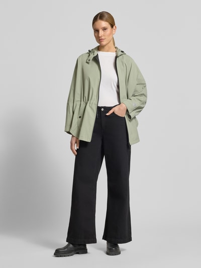 Vrouwenmodel draagt Jacke mit Kapuze und Label-Patch van Fuchs Schmitt in losvallende fit, lichtgroen, met kap, koordstoppers, tweewegsrits, drukknopzakken, labelpatch, lengte 83 cm, schouderbreedte 42 cm, borstwijdte 89 cm, mouwlengte 22 cm, vooraanzicht volledige lichaam.