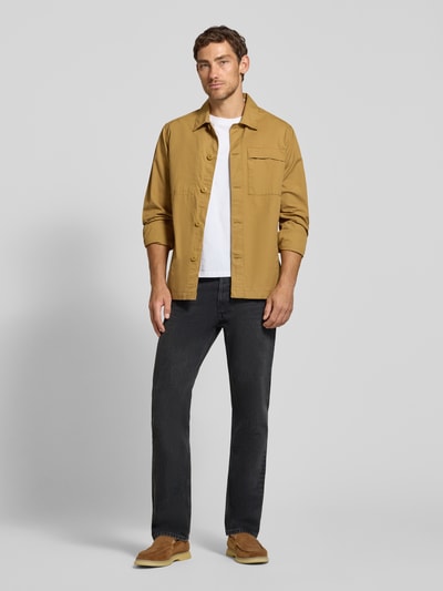 Männermodel trägt dunkle Straight Fit Jeans aus reiner Baumwolle Modell 'MAADOX' von ARMEDANGELS, Herrenmode, Ganzkörperansicht von vorne.