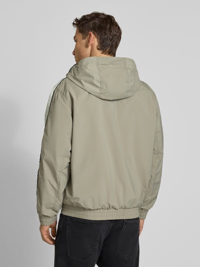 Männermodel trägt Regular Fit Jacke mit Kapuze Modell 'BAVO2621' von HUGO, unifarben, elastische Abschlüsse, Rückansicht Ganzkörperansicht.
