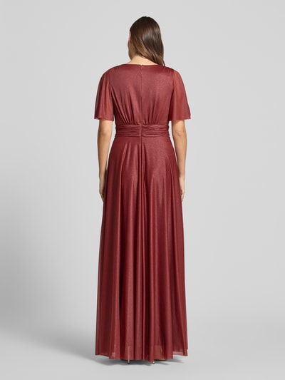 Modelka nosi 'Schimmerndes Maxikleid mit V-Ausschnitt und Taillenband' od Christian Berg Cocktail, efekt błyszczący, siateczka, linia a, dekolt w serek, tasiemka w talii, długość tyłu w rozmiarze 36: 149 cm, szerokość klatki piersiowej w rozmiarze 36: 35 cm, długość rękawów w rozmiarze 36: 29 cm, pełny widok z tyłu.