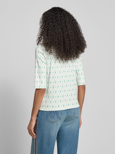 Frauenmodel trägt Slim Fit Poloshirt mit Logo-Applikation von Marc Cain im Allover-Motiv-Print, weiße Grundfarbe, Detailaufnahme Rückansicht.