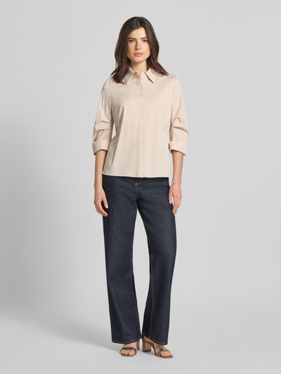 Frauenmodel trägt Hemdbluse mit 3/4-Arm mit Aufschlag von Marc Cain, beigefarbener Baumwoll-Viskose-Mix, Knopfleiste, Ganzkörperansicht von vorne.