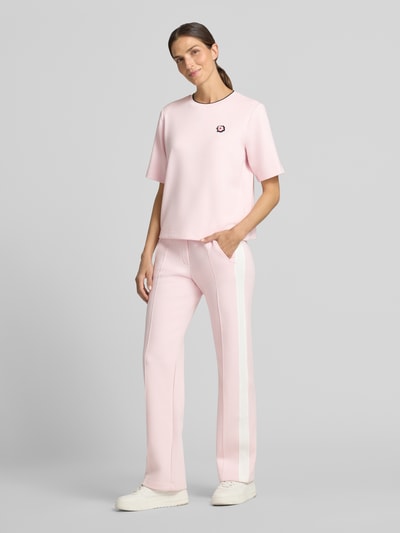 Vrouwenmodel draagt Relaxed Fit T-shirt uit viscosemix van Marc Cain in lichtroze met logodetail, ronde hals, ruglengte maat 36: 54 cm, elastische viscosemix, dames t-shirt, casual stijlen, relaxed fit, ganzlichaamsvooraanzicht.