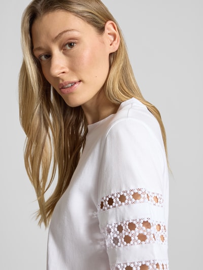 Frauenmodel trägt Damen T-Shirt mit 1/2-Arm Modell 'APE' von EMME aus Reine Baumwolle, Rundhalsausschnitt, Spitzenbesatz, Nahaufnahme Oberkörper.