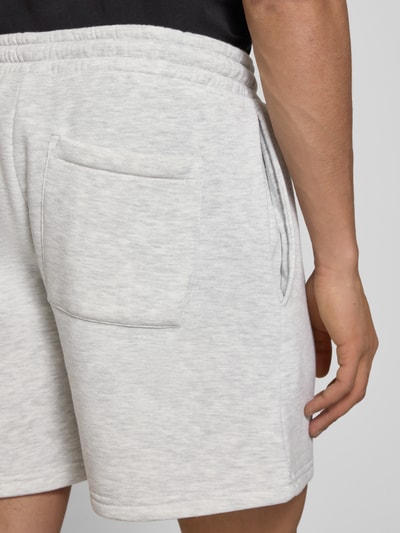 Männermodel trägt Shorts mit Gesäßtasche und Logo-Stitching von REVIEW, hellgrauer Baumwoll-Mix, Gerader-Schnitt, Nahaufnahme Rückansicht.