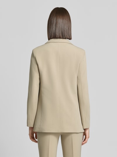 Frauenmodel trägt Regular Fit Longblazer mit Pattentaschen Modell 'C_Jabla3' von BOSS Orange in Beige, glatte Oberfläche, Ganzkörperansicht Rückansicht.