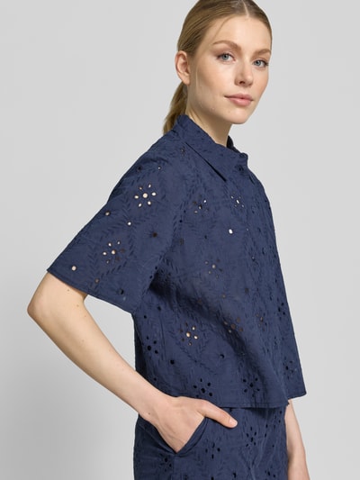 Kobiece model nosi Relaxed Fit Hemdbluse aus reiner Baumwolle Modell 'ELIZA' von Vero Moda, jednokolorowy, haft angielski, krój relaxed fit, kołnierzyk koszulowy, dekolt w serek, listwa guzikowa, rękaw o dł. 1/2, bawełna, widok z przodu w półzbliżeniu.