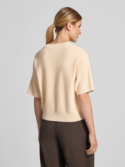 Frauenmodel trägt Relaxed Fit Pullover aus Viskose-Mix Modell 'Thamira' von MSCH Copenhagen in Beige, Strick-Optik, Ganzkörperansicht Rückansicht.