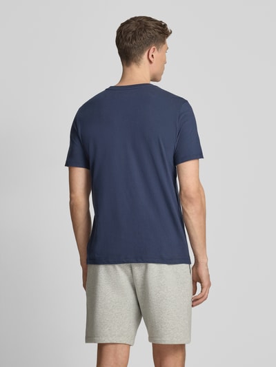 Männermodel trägt T-Shirt mit Logo und Rundhalsausschnitt von GAP in Dunkelblau aus Reine Baumwolle, Regular-Fit, Rückenlänge 69 cm, Ganzkörperansicht Rückansicht.