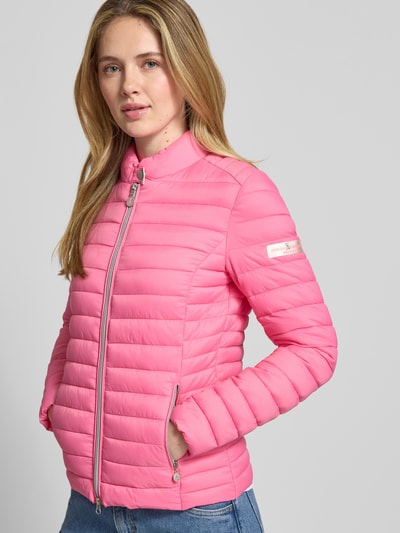 Modelka kobieca nosi Kurtka pikowana z zamkiem błyskawicznym dwustronnym model 'JUDY' od Frieda & Freddies, różowa, krój slim fit, stójka, kieszenie zapinane na zamek błyskawiczny, długość tyłu w rozmiarze 36: 57 cm, szerokość ramion w rozmiarze 36: 40 cm, szerokość klatki piersiowej w rozmiarze 36: 48 cm, długość rękawów w rozmiarze 36: 64 cm; widok całej sylwetki z przodu.