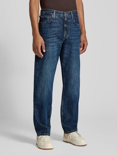 Männermodel trägt Straight Fit Jeans aus reiner Baumwolle Model 'DOVER' von Tommy Hilfiger, Herrenjeans, blaue Waschung, Ganzkörperansicht von vorne.