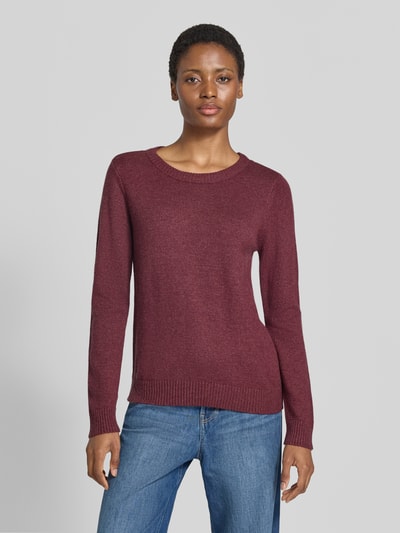 Frauenmodel trägt Strickpullover aus Viskose-Mix von VILA in Dunkelrot, taillierte Passform, gerippte Abschlüsse, Ganzkörperansicht von vorne.