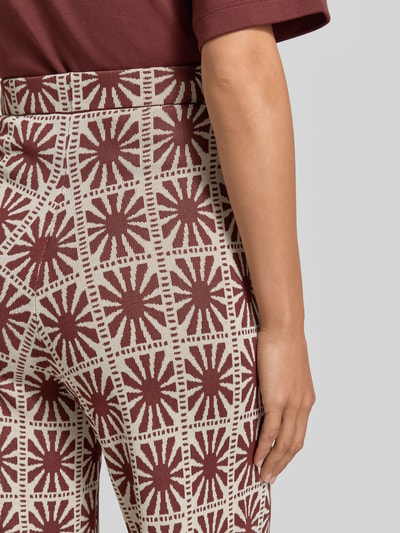 Frauenmodel trägt Flared Cut Hose im Allover-Look Modell 'JASPER' von SUNCOO PARIS aus Viskose-Mix mit elastischem Bund, Nahaufnahme Hüfte.