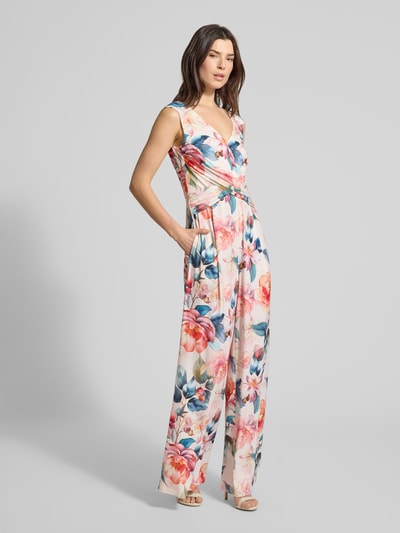 Modelka nosi Regular Fit Jumpsuit mit floralem Allover-Print od Vera Mont, elastyczna mieszanka materiałów, krój regular fit, kwiatowy nadruk na całej powierzchni, dekolt w serek, krój bez rękawów, wszyty zamek błyskawiczny, marszczenia, taliowany krój, długość tyłu w rozmiarze 36: 33 cm, szerokość w rozmiarze 36: 43 cm, całkowita długość w rozmiarze 36: 150 cm, długość wewnętrzna nogawki w rozmiarze 36: 83 cm, widok całej sylwetki z przodu