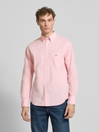 Mannenmodel draagt Slim Fit Freizeithemd met Logo-Stitching van Gant in lichtroze katoen, button-down kraag, borstzak, sportmanchet, langemouwen, voorkant volledig zichtbaar, volledig frontaal.
