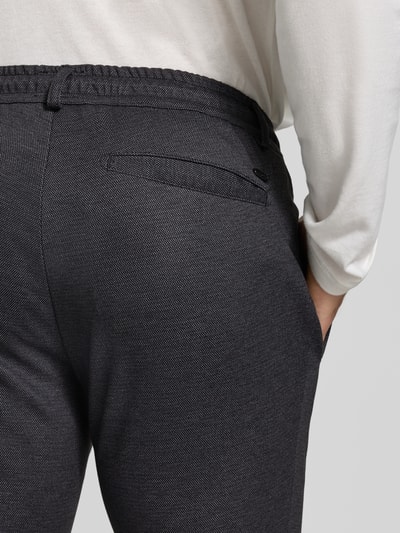 Männermodel trägt Tapered Fit Jogpants mit Viskose-Anteil Modell 'Phil' von Brax in Dunkelgrau, feine Struktur, Detailaufnahme, Herren Weite Hose von Brax.