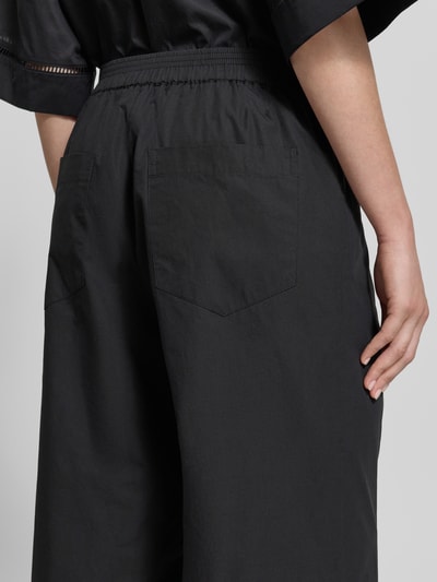 Vrouwenmodel draagt 'Hose aus Baumwolle mit elastischem Bund' van JAKE*S STUDIO WOMAN, relaxed fit, katoen, elastische tailleband, detailopname rug.