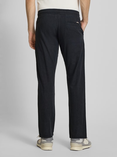 Männermodel trägt Hose aus Baumwoll-Leinen-Mix Modell 'KANE' von Jack & Jones in Dunkelblau, Regular-Fit, elastischer Bund, Ganzkörperansicht Rückansicht.