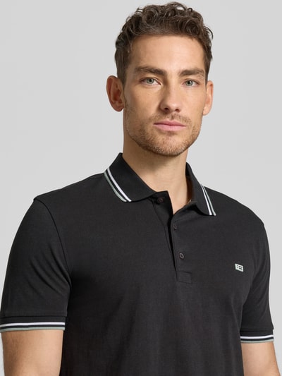 Männermodel trägt Regular Fit Poloshirt mit Kontraststreifen von Christian Berg Men aus Reine Baumwolle, Nahaufnahme Oberkörper.