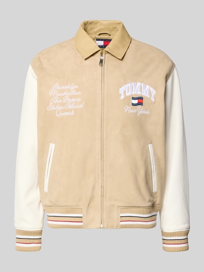 Produktfoto, Relaxed Fit College-Jacke aus echtem Leder von Tommy Jeans in Lederoptik mit Umlegekragen, Label-Schriftzug, Applikation, Label-Stitching, Reißverschluss, seitlichen Paspeltaschen, Napoleontasche, Materialverarbeitung Veloursleder und Glattleder, Farbe Beige und Weiß, Passform Relaxed-Fit