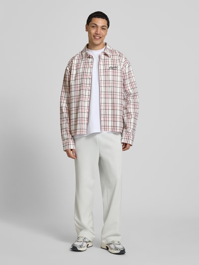 Männermodel trägt Oversized Freizeithemd mit Label-Stitching Modell 'Soglio' von Pegador, kariert, Reine Baumwolle, Ganzkörperansicht von vorne.