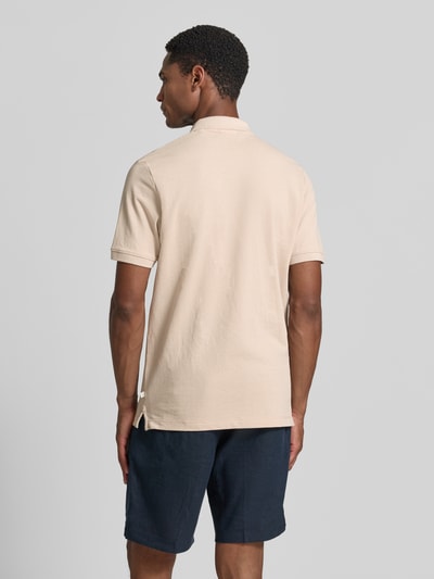 Männermodel trägt Regular Fit Poloshirt aus Baumwoll-Mix von s.Oliver RED LABEL in Beige, glatte Textur, Ganzkörperansicht Rückansicht.