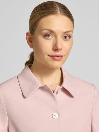 Kobiece model prezentuje Regular Fit Blazer aus Viskose-Mix mit Pattentaschen od More & More, jasnoróżowy, faktura gładka, kołnierz wykładany, zapięcie na guziki, detaliczne naszywane kieszenie z patkami, krój regular fit, viskoza ze streczem, szerokość w rozmiarze 36: 47 cm, długość tyłu 51 cm, długość rękawa 46 cm, zbliżenie na górną część ciała z przodu.