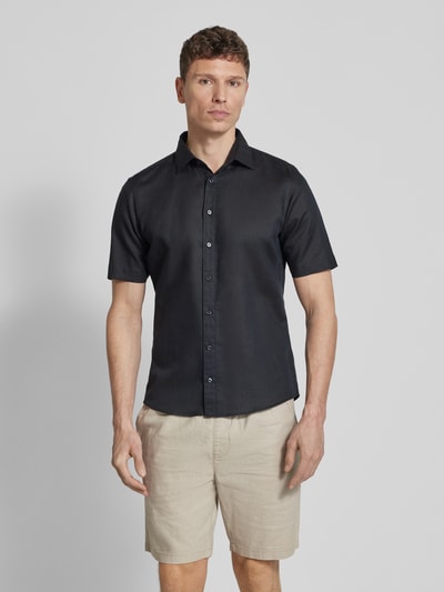Männermodel trägt Slim Fit Freizeithemd aus Leinen-Mix von Jake*s, schwarzes Hemd mit Kentkragen, kurzärmelig, Ganzkörperansicht von vorne.