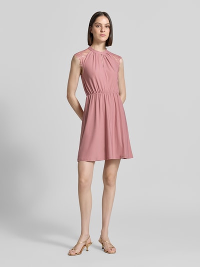 Frauenmodel trägt Tailliertes Freizeitkleid mit Spitzenbesatz Modell 'MILLA' von Vero Moda, Optik: Unifarben, Kurzarm, Mini-Länge, Stretch. Ganzkörperansicht von vorne.