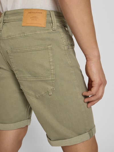 Mannenmodel draagt Regular Fit Shorts met omslag model 'RICK' van Jack & Jones, katoenmix met stretch, steekzakken, detailopname rugaanzicht.